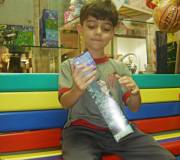 Foto de Daniel, menino de 6 anos, em uma loja de brinquedos escolhendo seu presente de Dia das Crian?as